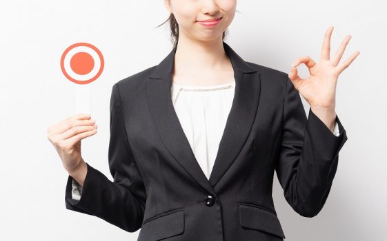 ○の札を持つ女性